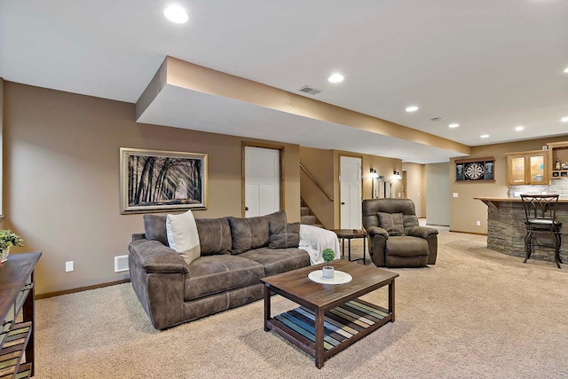 living room featuring light carpet, recessed lighting, a bar, and baseboards