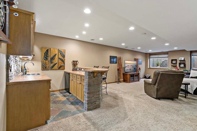 bar with baseboards, recessed lighting, a sink, bar, and dark carpet