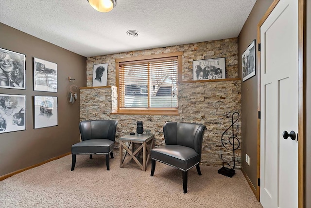 sitting room featuring visible vents, carpet floors, a textured ceiling, and baseboards