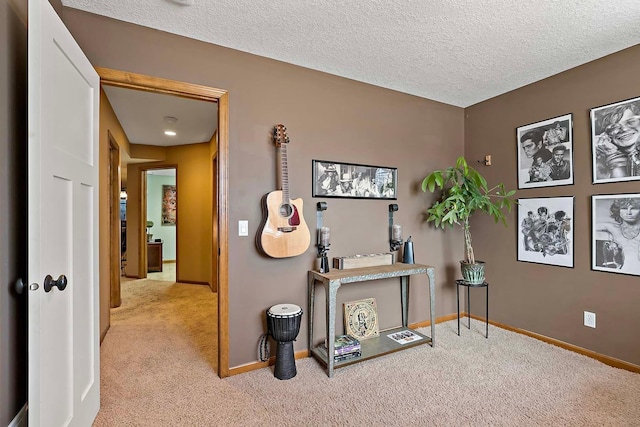 hall featuring carpet flooring, a textured ceiling, and baseboards