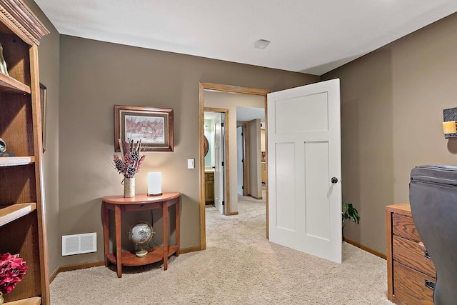 interior space with visible vents, light colored carpet, and baseboards