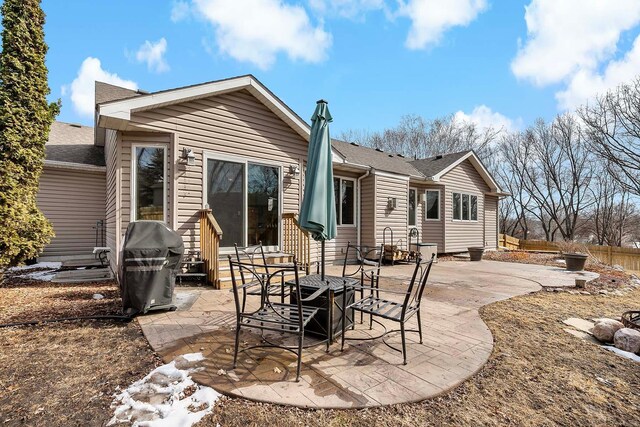 back of property with a patio, fence, and a shingled roof