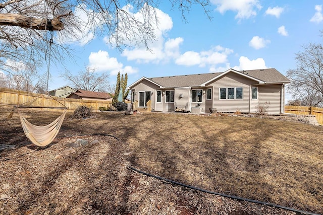 back of property featuring a yard and fence