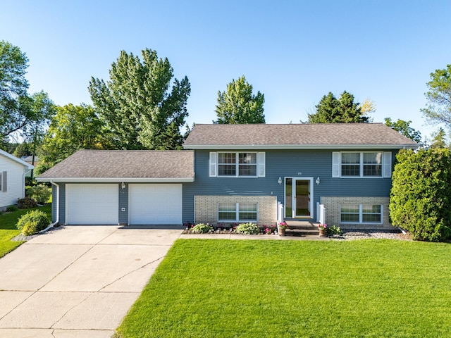 split foyer home with an attached garage, concrete driveway, and a front yard