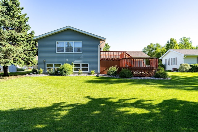 rear view of house featuring a deck and a lawn