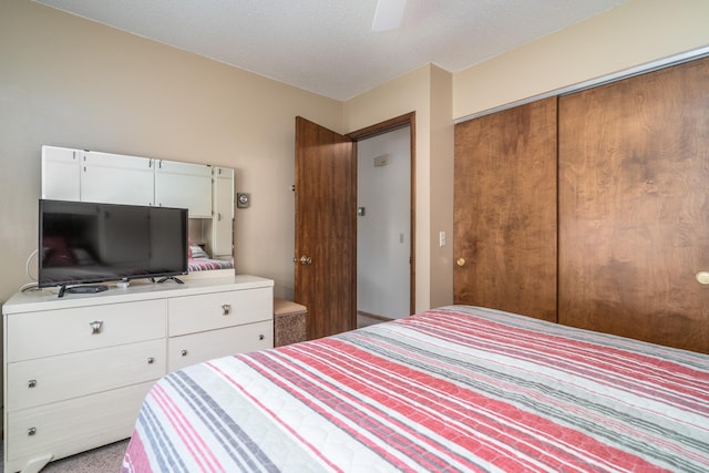 bedroom featuring a textured ceiling, a ceiling fan, and a closet