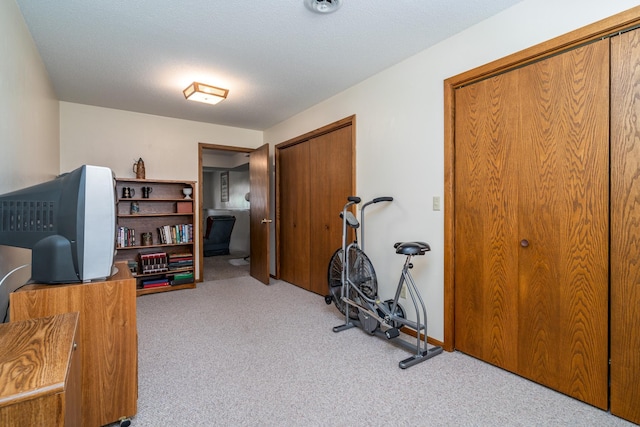 exercise room featuring carpet and a textured ceiling