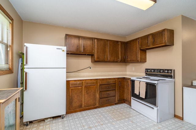 kitchen featuring white appliances, light countertops, and light floors