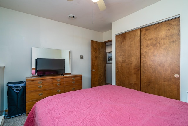 bedroom featuring a closet, carpet flooring, visible vents, and a ceiling fan