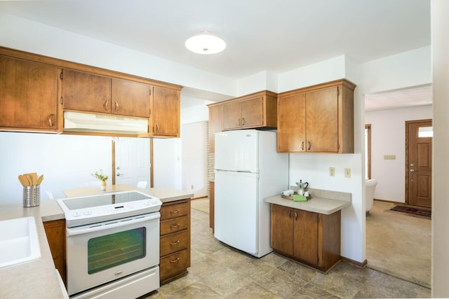 kitchen featuring under cabinet range hood, brown cabinetry, white appliances, and light countertops