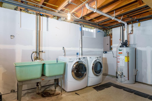 clothes washing area with washing machine and clothes dryer, gas water heater, electric panel, laundry area, and tile patterned floors