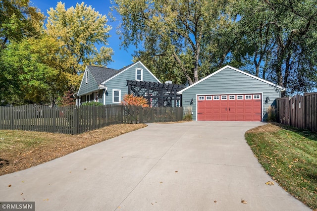 exterior space with driveway, fence, and a pergola