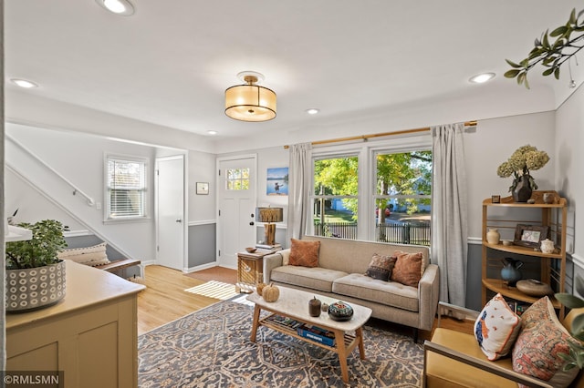 living area with a healthy amount of sunlight, light wood-style flooring, stairs, and recessed lighting