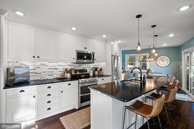 kitchen featuring backsplash, appliances with stainless steel finishes, white cabinets, and dark wood-type flooring