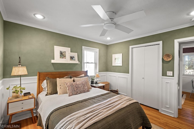 bedroom featuring a closet, multiple windows, and wood finished floors