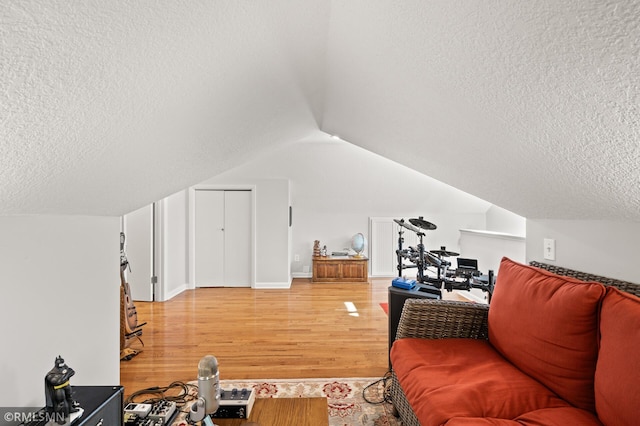 interior space with lofted ceiling, light wood-style floors, and a textured ceiling