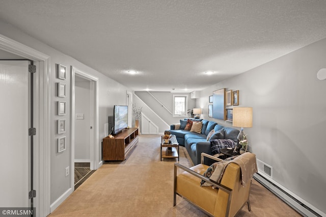 living area with light colored carpet, stairway, baseboard heating, a textured ceiling, and baseboards