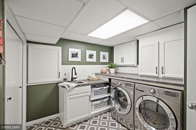 laundry area with washer and clothes dryer, a sink, cabinet space, and tile patterned floors