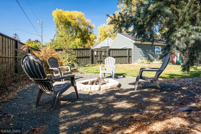 view of yard featuring a fire pit, a patio area, and fence