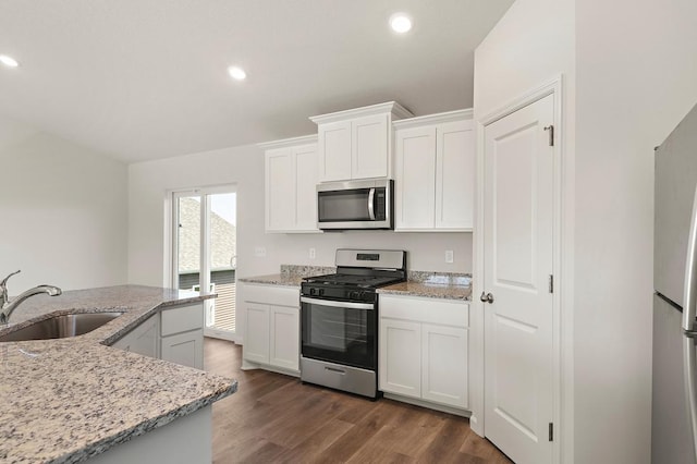 kitchen with recessed lighting, stainless steel appliances, a sink, white cabinets, and dark wood finished floors