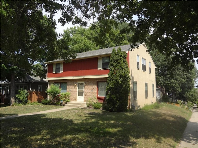 view of front of home with brick siding and a front lawn