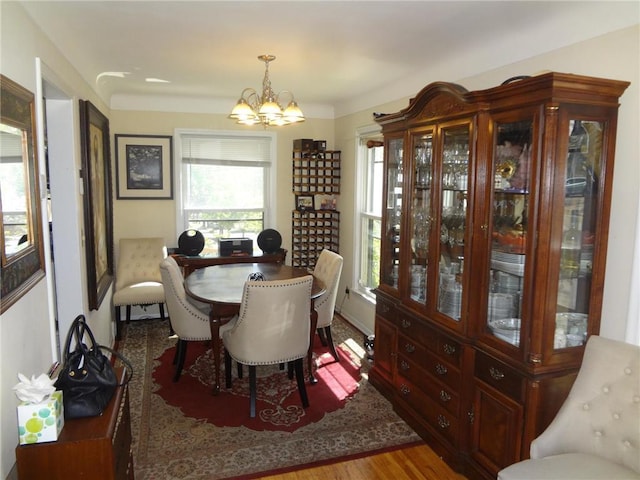 dining space featuring wood finished floors and an inviting chandelier