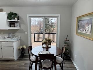 dining space featuring dark wood-style flooring and baseboards