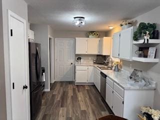 kitchen with white cabinets, light countertops, stainless steel dishwasher, freestanding refrigerator, and dark wood finished floors