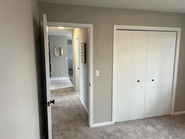 unfurnished bedroom featuring a closet, carpet, and baseboards