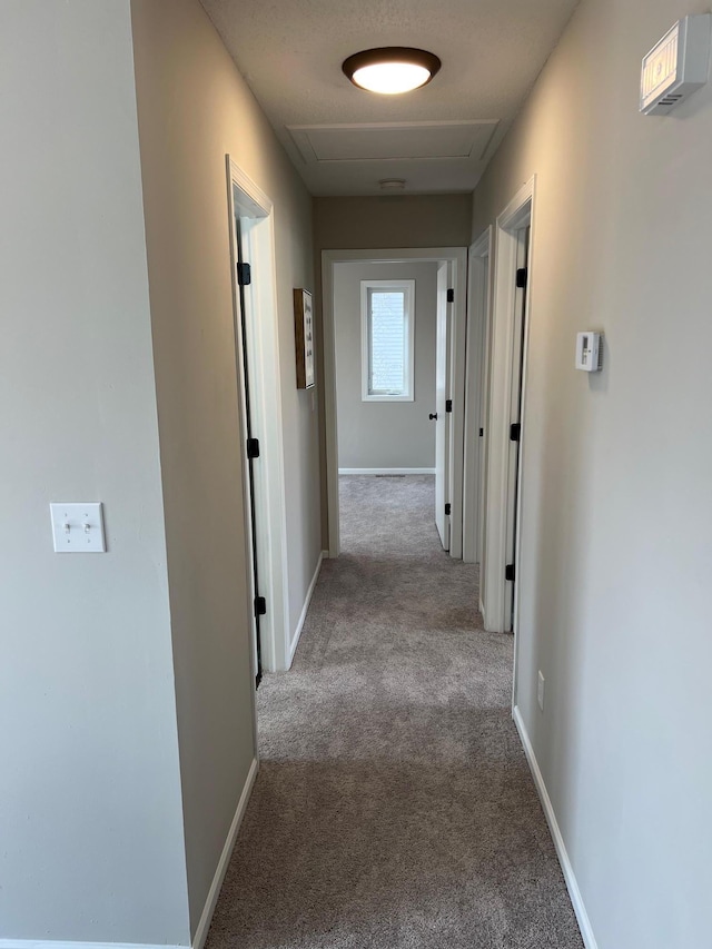 hallway with carpet and baseboards