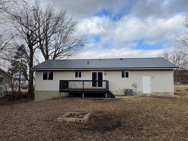 rear view of property featuring metal roof, cooling unit, and a wooden deck