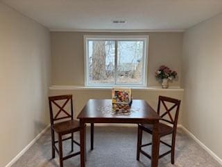 dining room featuring breakfast area, carpet, and baseboards