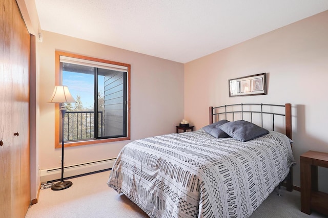 bedroom with a baseboard heating unit, carpet flooring, and baseboards