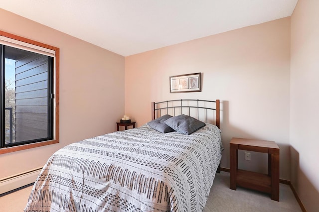 carpeted bedroom featuring a baseboard heating unit and baseboards