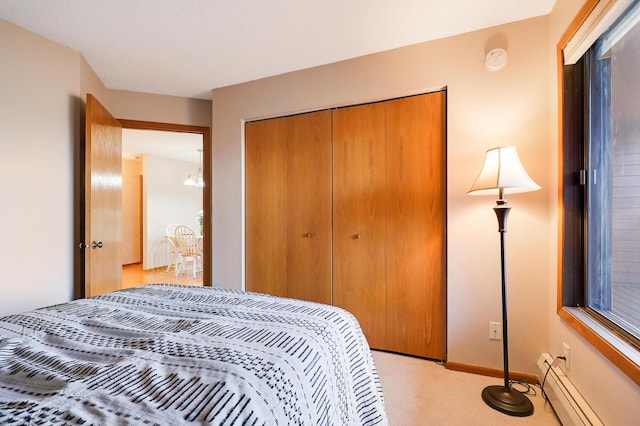 bedroom featuring light carpet, a baseboard radiator, baseboards, and a closet