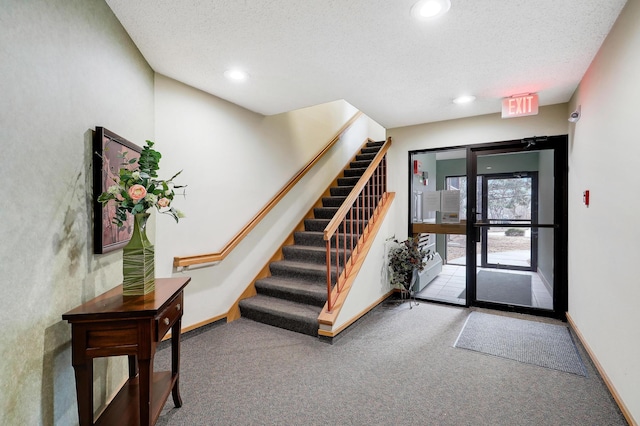 carpeted foyer featuring stairs, baseboards, a textured ceiling, and recessed lighting