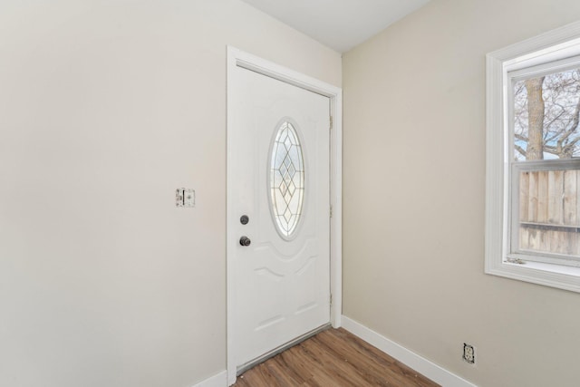 foyer with baseboards and wood finished floors