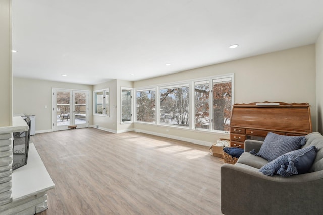 living area with recessed lighting, baseboards, and wood finished floors