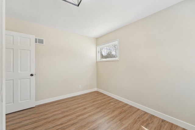 spare room featuring visible vents, light wood-style flooring, and baseboards