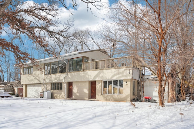 view of front facade featuring a garage, a balcony, and stucco siding