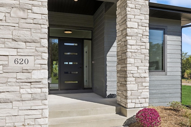 property entrance featuring stone siding