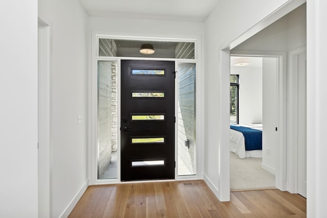 entrance foyer featuring baseboards and wood finished floors