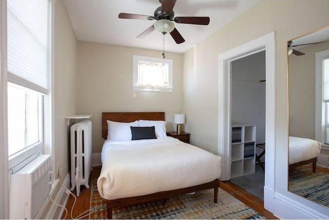 bedroom featuring radiator, ceiling fan, and wood finished floors