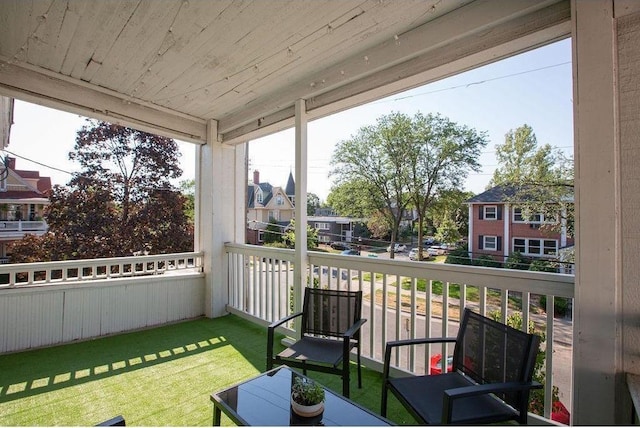 sunroom with a residential view and wood ceiling