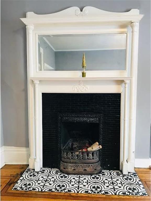 room details with a tiled fireplace, wood finished floors, and baseboards