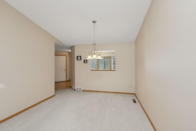 empty room featuring light colored carpet, visible vents, and baseboards