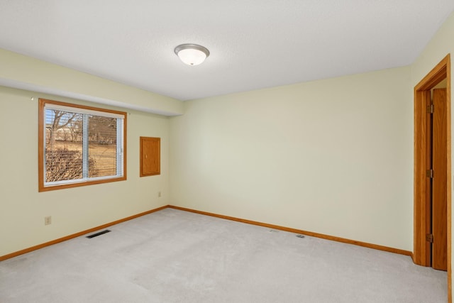 unfurnished room featuring baseboards, visible vents, and light colored carpet