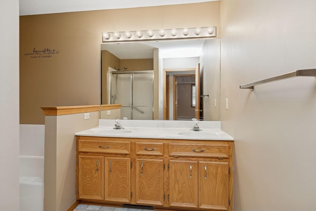 bathroom featuring a sink, a shower stall, a bath, and double vanity