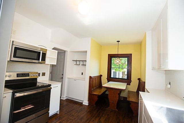 kitchen featuring stainless steel appliances, light countertops, dark wood finished floors, and white cabinetry