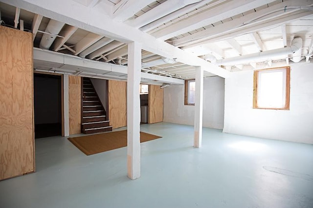 basement featuring a healthy amount of sunlight and stairway